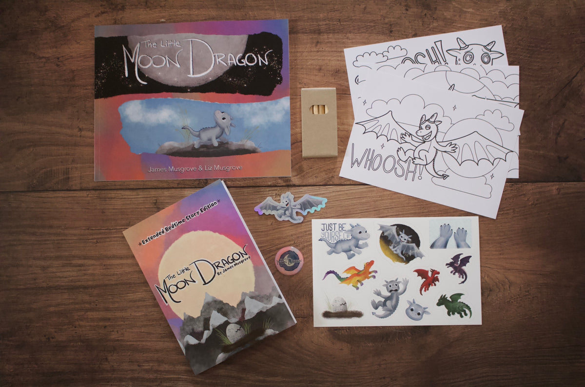 A children's dragon-themed activity set arranged on a wooden tabletop, including a book titled 'The Light Moon Dragon’, colouring pages, a sticker sheet, and individual stickers. 