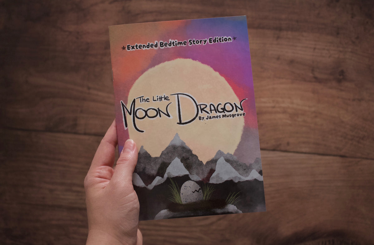 A hand holds a children's book titled 'The Little Moon Dragon' by James Musgrove, featuring a colourful cover illustration of a large moon over mountains, against a dark wood background.
